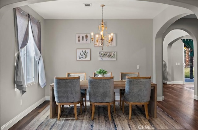 dining room featuring dark hardwood / wood-style floors and a chandelier