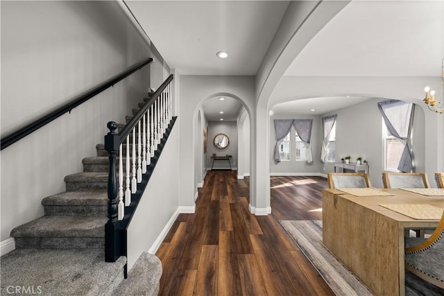 entrance foyer with an inviting chandelier and dark wood-type flooring