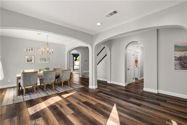 dining room featuring dark hardwood / wood-style floors and an inviting chandelier