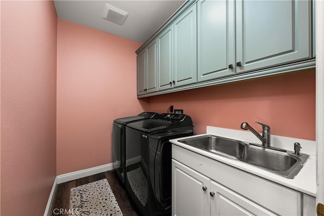 laundry room with cabinets, dark hardwood / wood-style flooring, sink, and independent washer and dryer