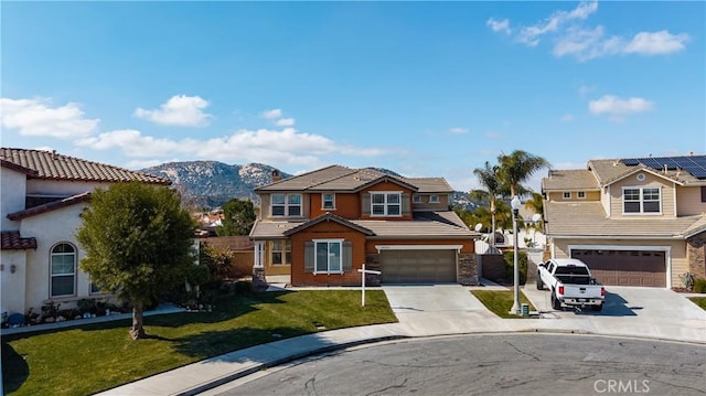 view of front of property with a garage, a mountain view, and a front yard