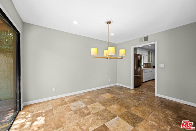 unfurnished dining area featuring a notable chandelier