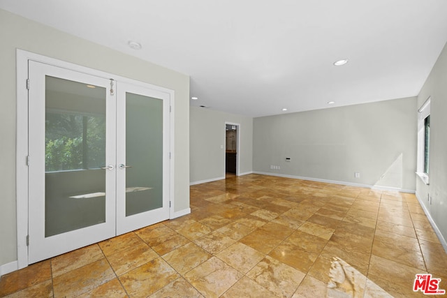 unfurnished room featuring french doors