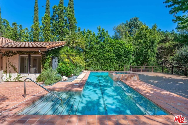 view of pool with a patio area and an in ground hot tub