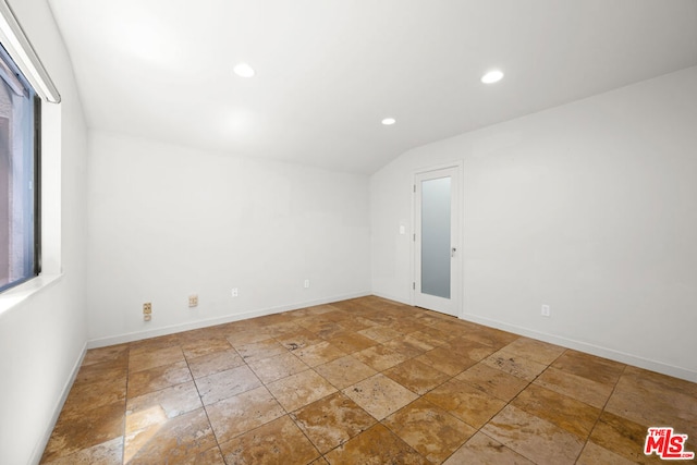 unfurnished room featuring lofted ceiling