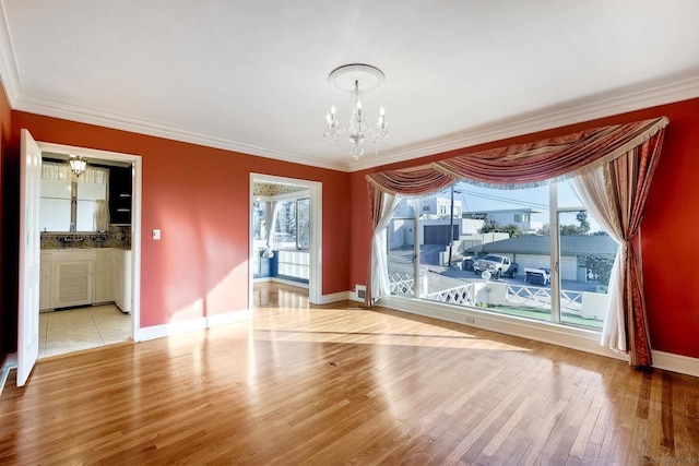 interior space with an inviting chandelier, crown molding, and light hardwood / wood-style floors