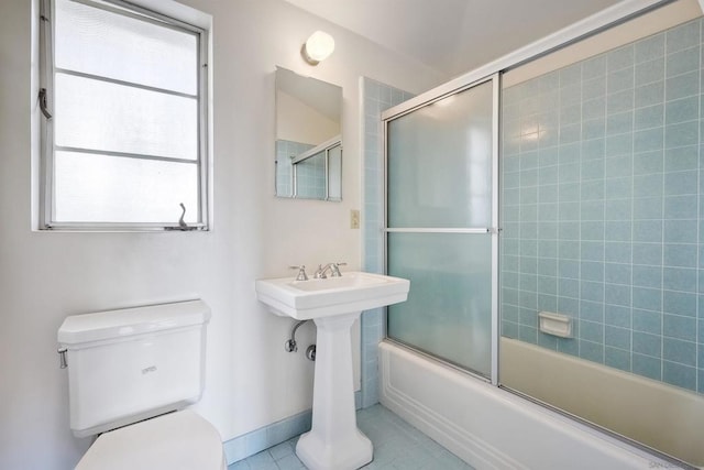 bathroom featuring tile patterned floors, shower / bath combination with glass door, and toilet