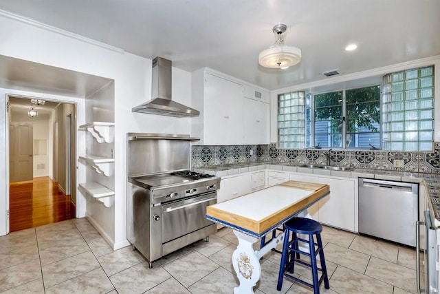 kitchen featuring white cabinetry, appliances with stainless steel finishes, light tile patterned flooring, and wall chimney exhaust hood