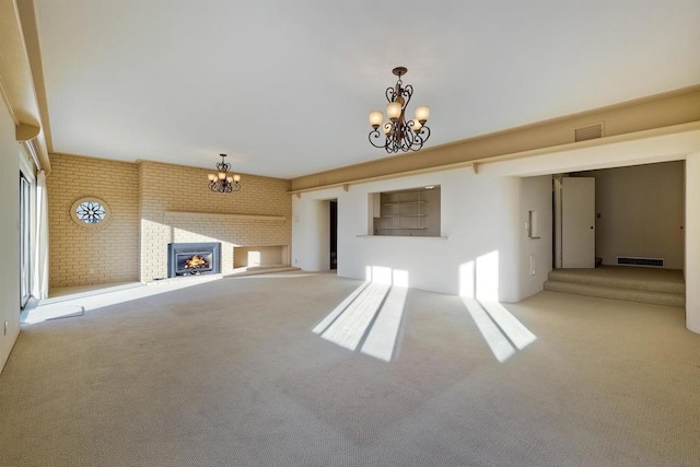 unfurnished living room with brick wall, carpet flooring, an inviting chandelier, and a fireplace