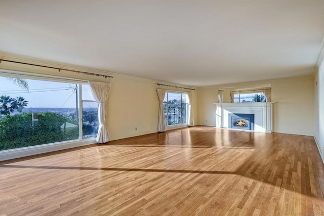 unfurnished living room featuring crown molding and hardwood / wood-style floors