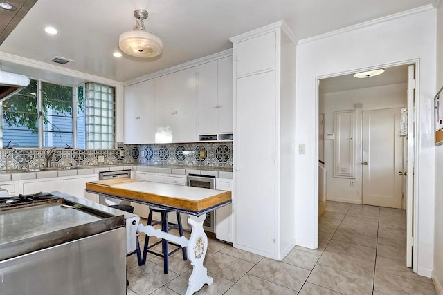 kitchen with sink, crown molding, decorative light fixtures, decorative backsplash, and white cabinets