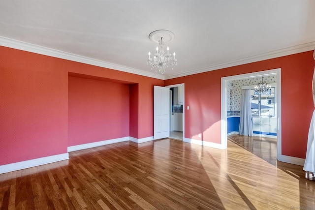 empty room with an inviting chandelier, ornamental molding, and wood-type flooring