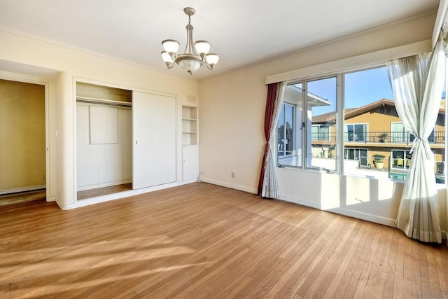 unfurnished bedroom with light hardwood / wood-style flooring, a closet, and a notable chandelier