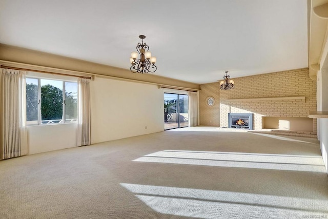 unfurnished living room with a chandelier, carpet, and a brick fireplace