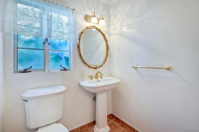 bathroom with sink, toilet, and tile patterned flooring