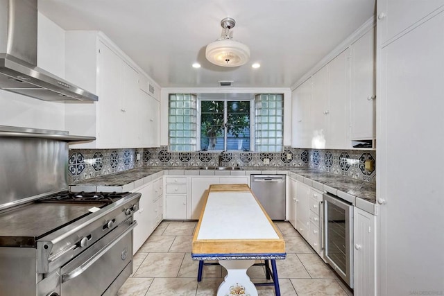 kitchen with stainless steel appliances, white cabinets, wine cooler, and wall chimney exhaust hood