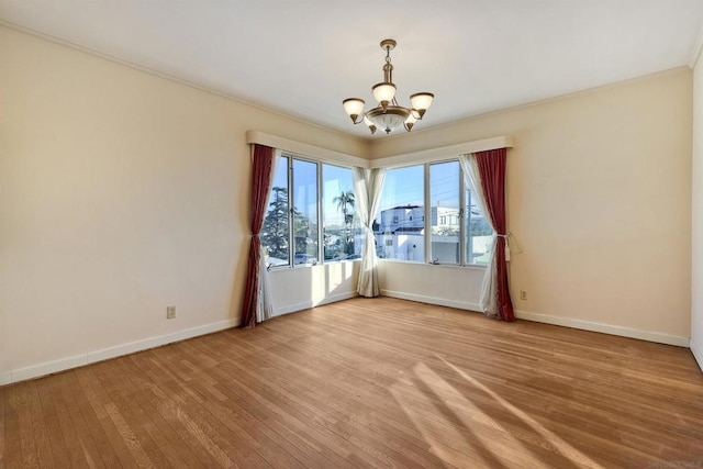 unfurnished room featuring an inviting chandelier and light hardwood / wood-style floors