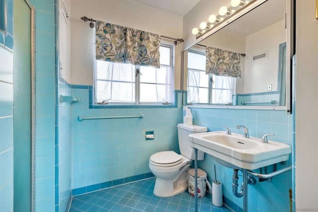 bathroom with tile walls, tile patterned flooring, and toilet