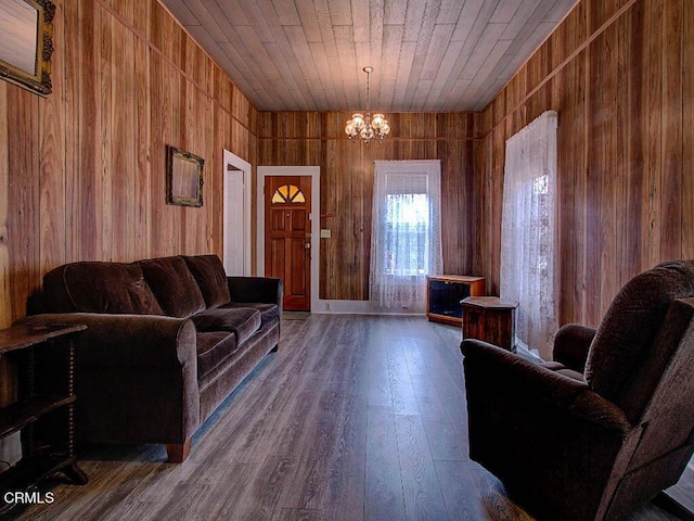 living room featuring hardwood / wood-style flooring, wooden ceiling, a chandelier, and wood walls