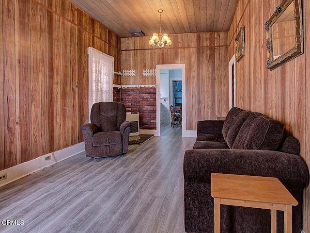 living room with wood ceiling, a notable chandelier, hardwood / wood-style flooring, and wood walls