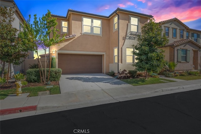 view of front of house featuring a garage, fence, a tiled roof, concrete driveway, and stucco siding