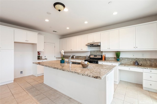 kitchen featuring range with gas stovetop, white cabinets, a sink, and under cabinet range hood