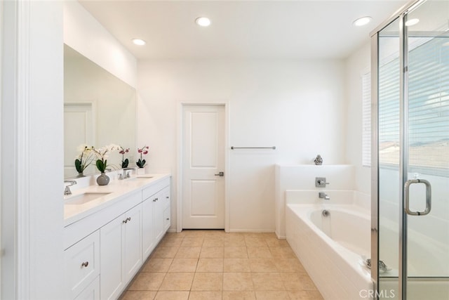 full bath with double vanity, a garden tub, a sink, and tile patterned floors