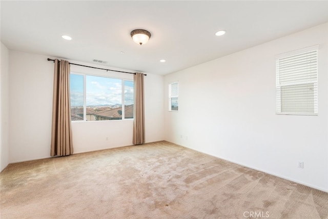 empty room featuring carpet floors, visible vents, and recessed lighting