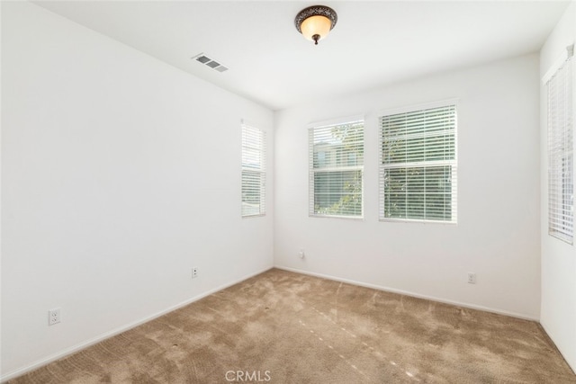 spare room featuring carpet floors and visible vents