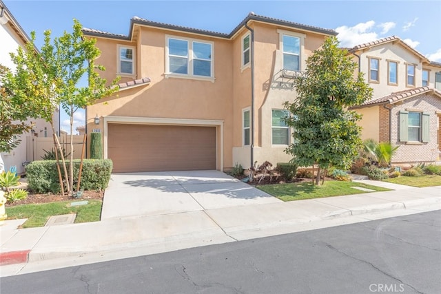 view of front of home featuring a tile roof, stucco siding, fence, a garage, and driveway