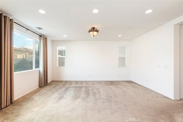 empty room with recessed lighting, visible vents, and light carpet