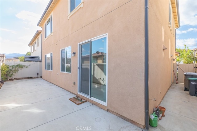 back of property with a patio, fence, and stucco siding