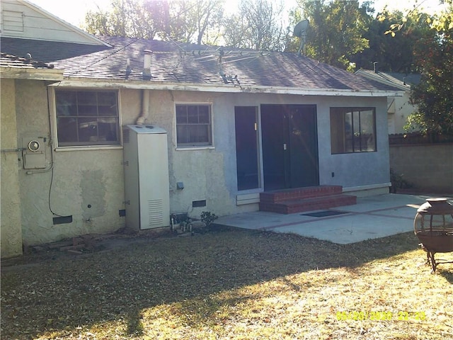 rear view of property featuring a lawn and a patio