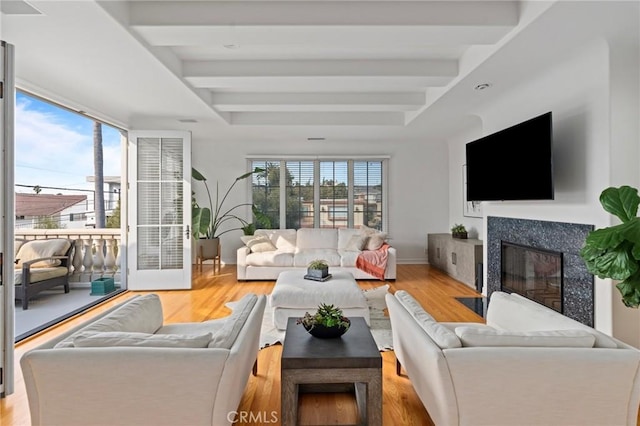 living room with a high end fireplace and light wood-type flooring