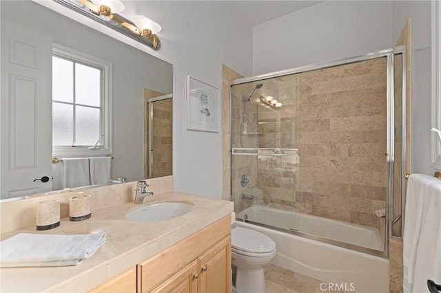 full bathroom with enclosed tub / shower combo, vanity, and toilet