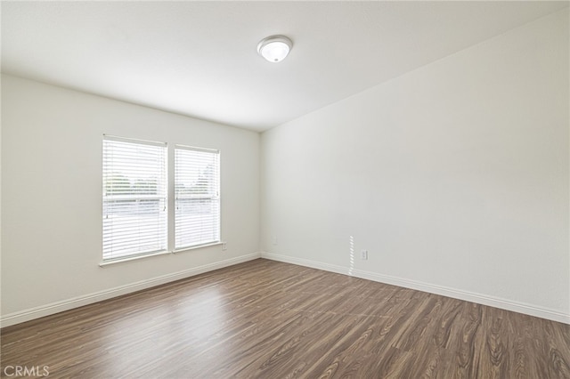 unfurnished room with dark wood-type flooring