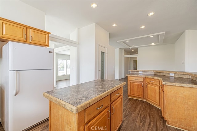 kitchen with dark hardwood / wood-style floors, a center island, and white refrigerator