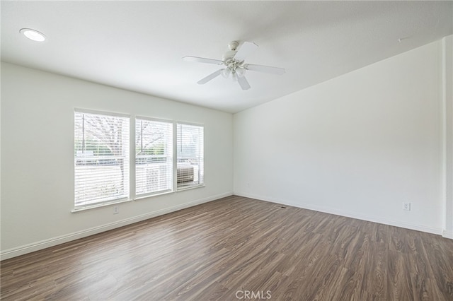 empty room with dark hardwood / wood-style floors and ceiling fan