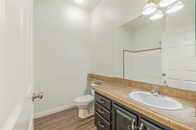 bathroom with wood-type flooring, vanity, and toilet