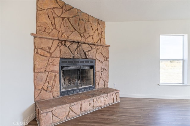 details featuring hardwood / wood-style floors and a stone fireplace