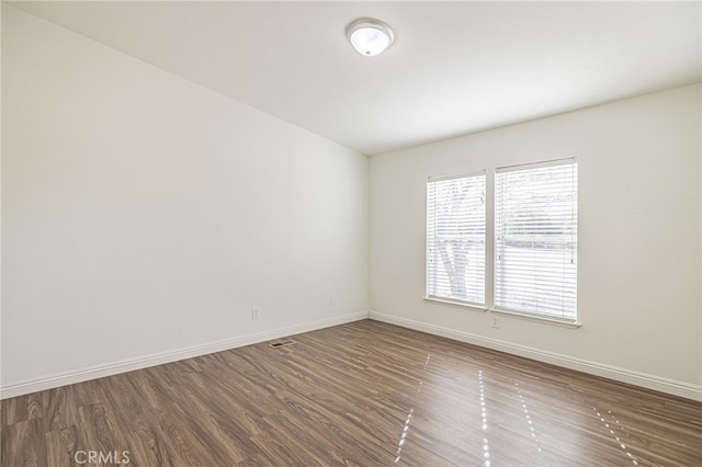 spare room featuring dark wood-type flooring