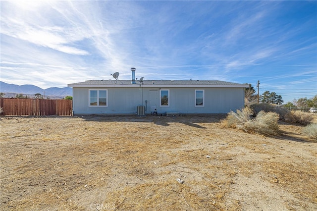 rear view of house with a mountain view and central AC