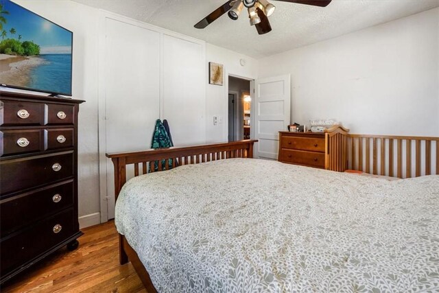 bedroom with light hardwood / wood-style floors, a closet, and ceiling fan