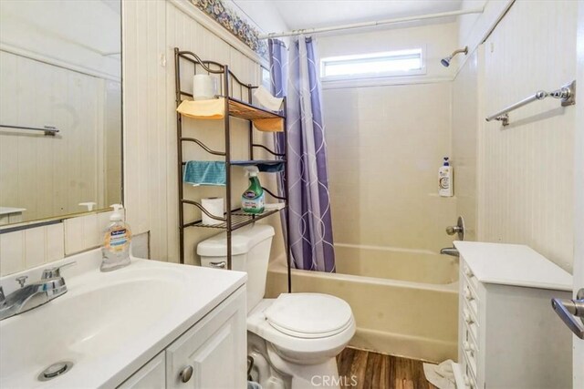 full bathroom with hardwood / wood-style flooring, shower / bathtub combination with curtain, vanity, and toilet