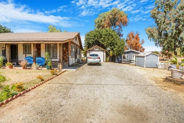 view of front of house with a garage and a storage shed