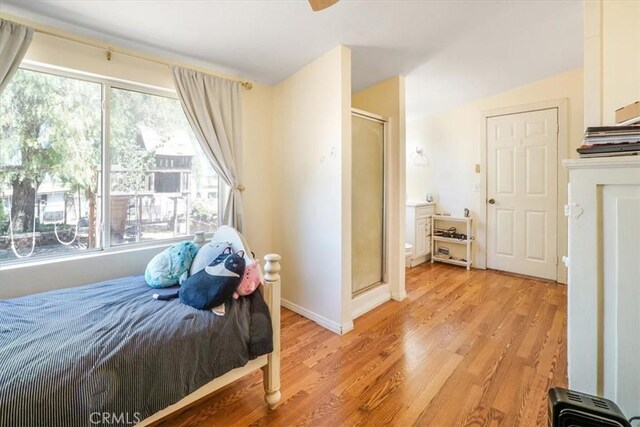 bedroom with multiple windows and light hardwood / wood-style flooring