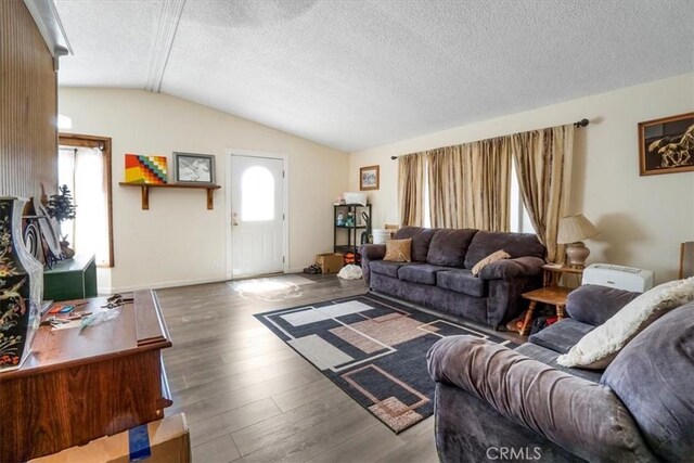 living room with lofted ceiling, a healthy amount of sunlight, hardwood / wood-style flooring, and a textured ceiling