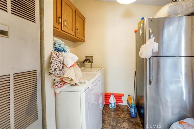 clothes washing area featuring cabinets and independent washer and dryer