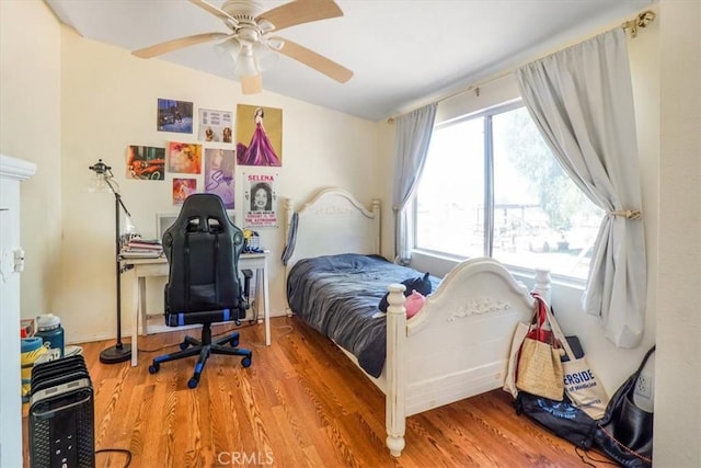 bedroom with ceiling fan, wood-type flooring, and vaulted ceiling