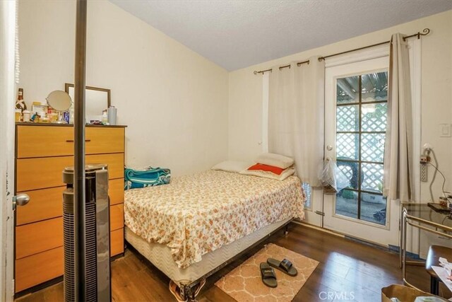 bedroom with dark hardwood / wood-style flooring and access to exterior